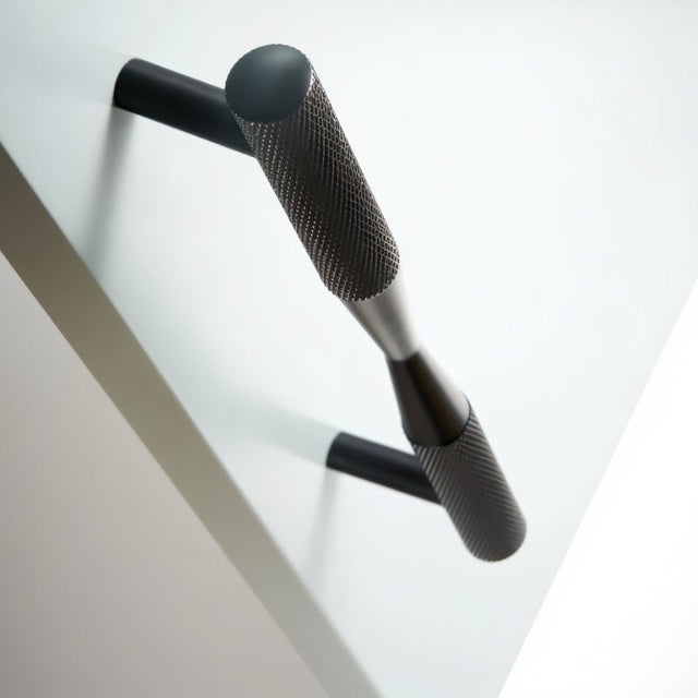 "Close-up of a black brass pull bar handle with knurled detailing, showcasing its cylindrical design and modern aesthetic."