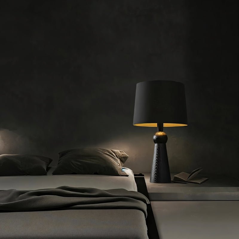 "Stylish bedside table lamp with wooden base and fabric shade, providing soft lighting in a cozy bedroom, made with durable wood and fabric."