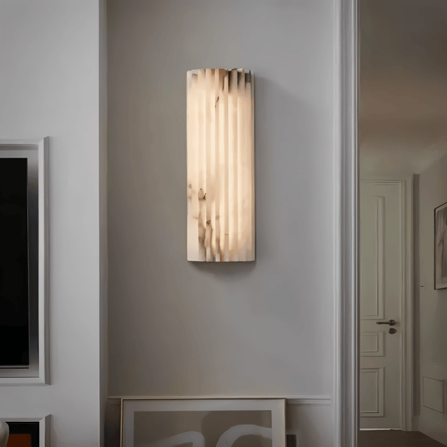 "Modern cloud stone wall lamp with vertical grooves, providing ambient lighting in a contemporary living room."