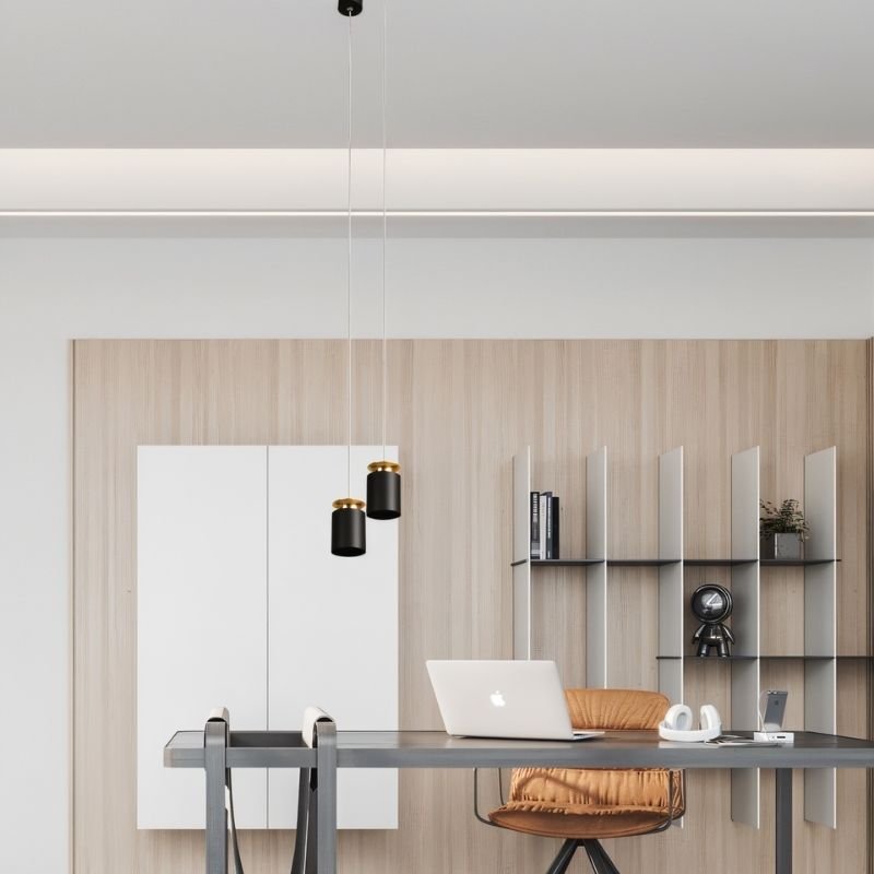 "Minimalist aluminum pendant lights hanging over a workspace, matte black finish, golden accents, sleek design"