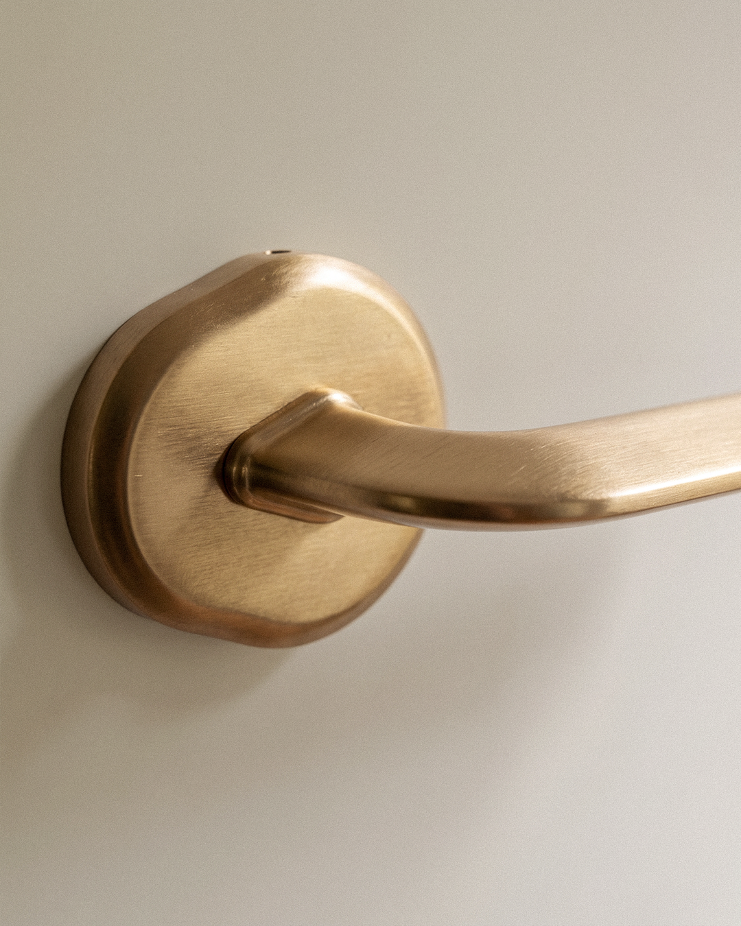 Enzo Door Handle in Satin Brass, on a plain background