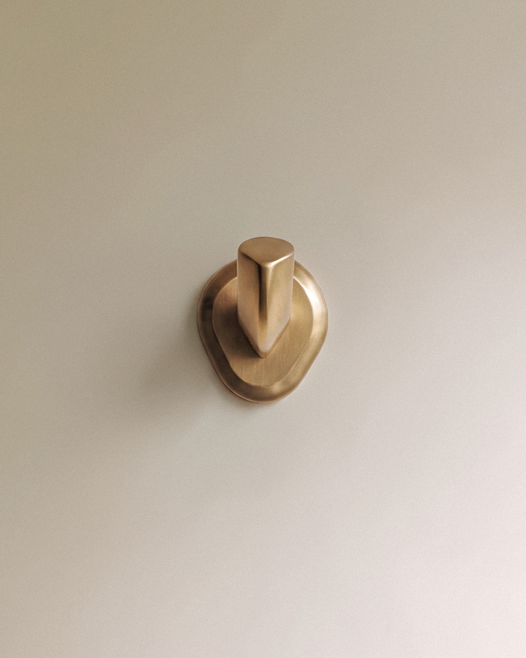 Enzo Wall Hook in Satin Brass, on a plain background