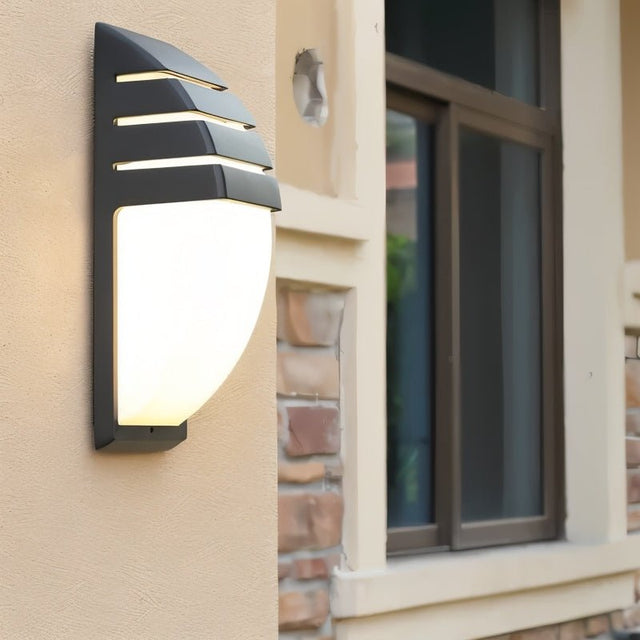 "Weatherproof outdoor wall lamp mounted on exterior wall, made from durable aluminum, casting soft light."