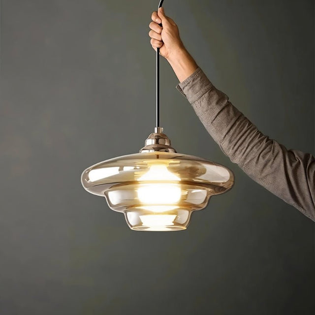 "Thuli pendant light with a minimalist hanging design, made from glass and iron for modern interiors."