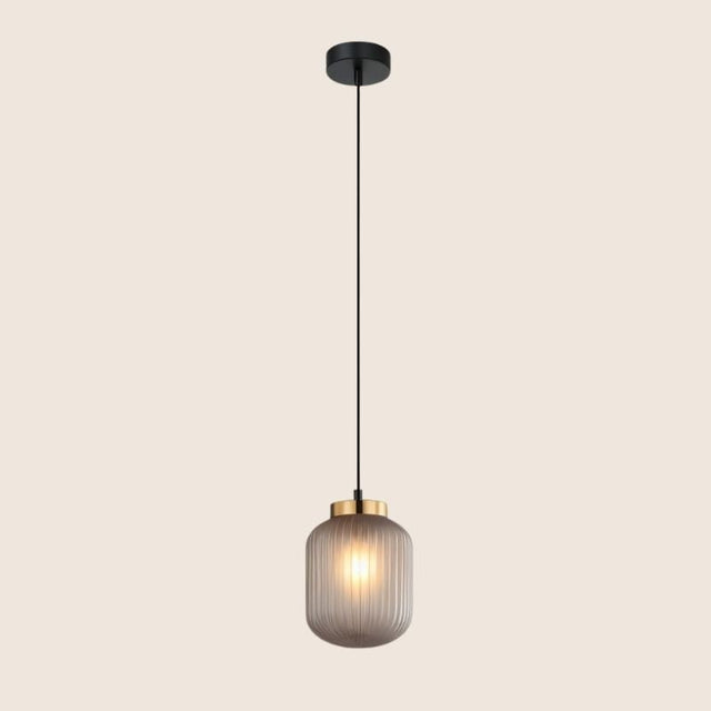 "Sleek pendant light with gray glass shade and gold accent, hanging in a minimalist style."