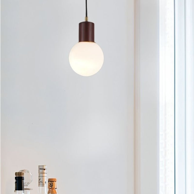"Spherical pendant light with a wooden holder, made from high-quality wood, providing even illumination in a contemporary setting."