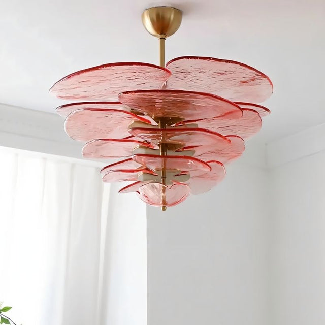 "A pink Murano glass chandelier with layered petals, viewed from below against a white ceiling and curtain."