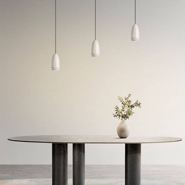 Three Ailis Pendant Lights in white suspended above a dining table, creating a contemporary ambiance with integrated LED lighting.