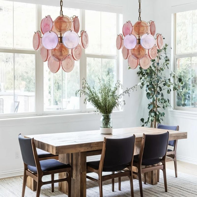 "Two Murano glass disc chandeliers in a dining room."