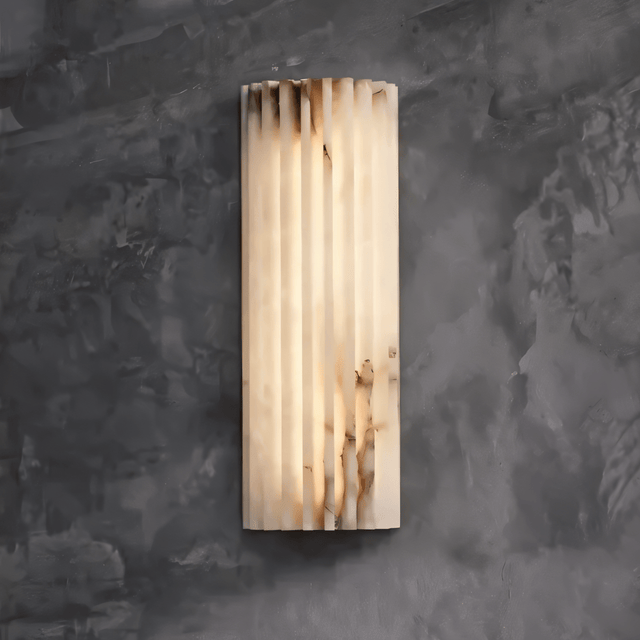 "Modern wall lamp crafted from cloud stone with a vertically grooved design, emitting a warm, diffused light."
