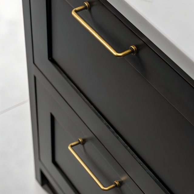 "Two minimalist antique brass pull bar handles made of durable zinc, installed on black drawers with a white countertop."