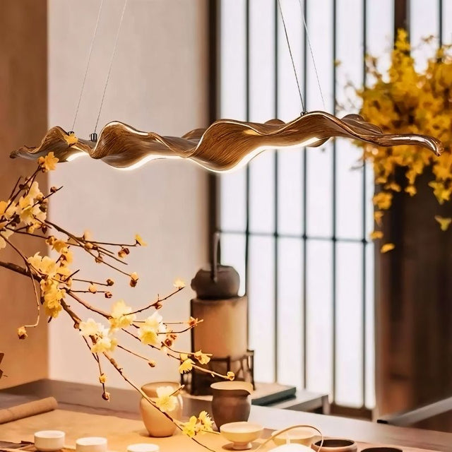 "Fiberglass and acrylic wave-shaped chandelier hanging above a dining area, creating a modern, artistic atmosphere."