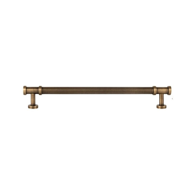 "A long antique brass fluted pull bar with detailed end caps, isolated on a white background."