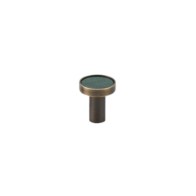 "Green leather and brass knob with stitching detail, isolated on a white background."