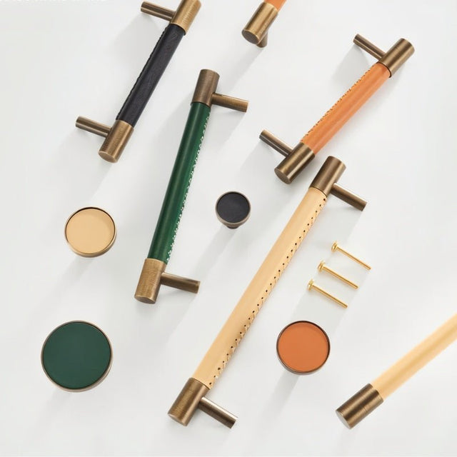 "Modern brass and leather pull bars and knobs in various colors with screws on a white background."
