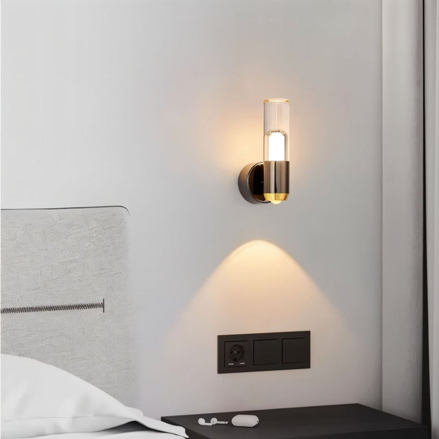 "Modern cylindrical wall lamp with a metal base and acrylic diffuser, used as a bedside sconce."