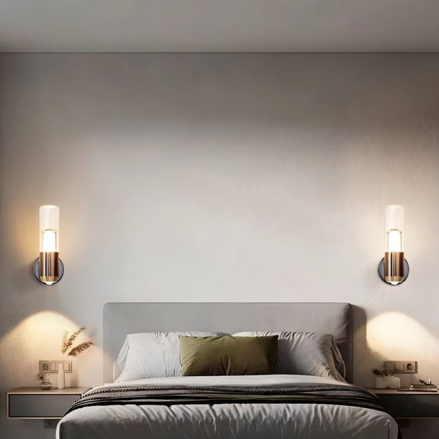 "Pair of modern cylindrical wall lamps with metal bases and acrylic diffusers flanking a bed in a contemporary bedroom."