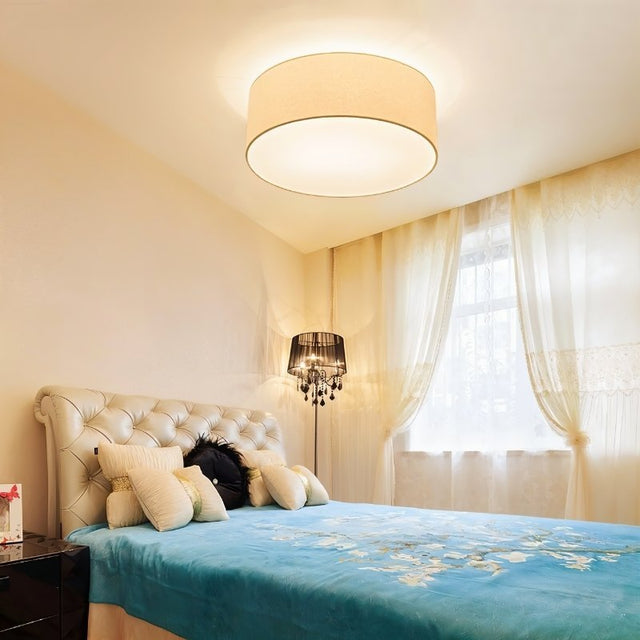 "Contemporary bedroom featuring a minimalist fabric drum ceiling light providing soft, ambient illumination."