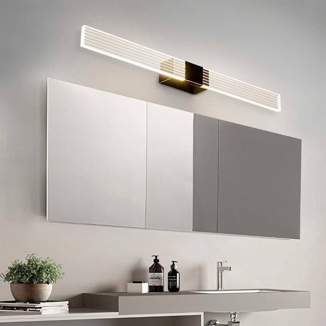 "Long, modern bathroom vanity light with a minimalist design above a large mirror."