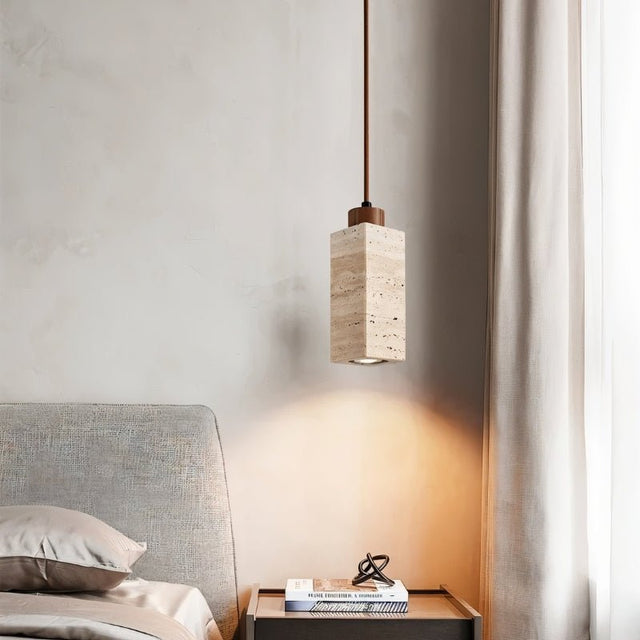 "Modern minimalist pendant light with a rectangular travertine body, adding a touch of rustic charm to a contemporary bedroom."