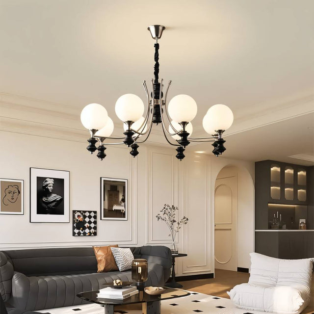 "Modern chandelier with curved arms and frosted glass globes in a contemporary living room with a gray sofa."