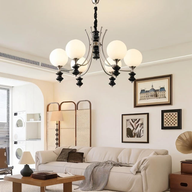 "Modern chandelier with curved arms and frosted glass globes illuminating a contemporary living room."