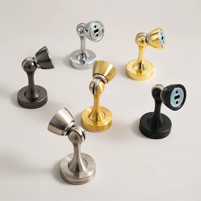 "Collection of sleek, zinc-alloy magnetic door stops with contoured designs in various finishes, designed to prevent door slams and wall damage in modern interiors."