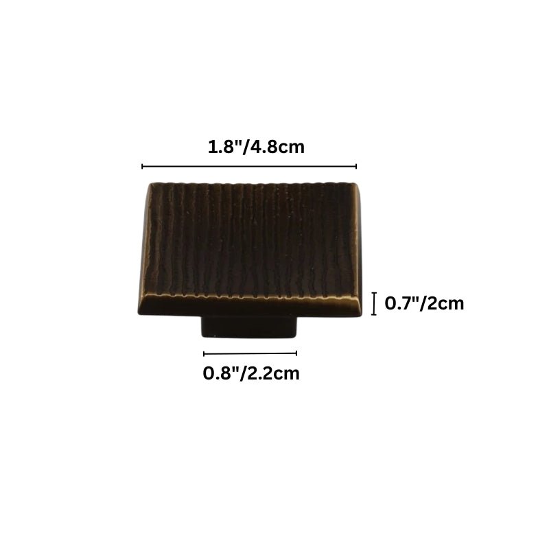 "Studio shot of a brass square cabinet knob with a textured surface, shown with dimensions in inches and centimeters on a white background."