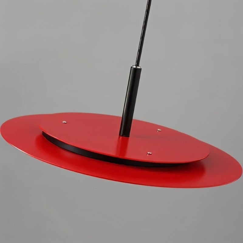 "A disc-shaped pendant light hanging above a kitchen island with bar stools."