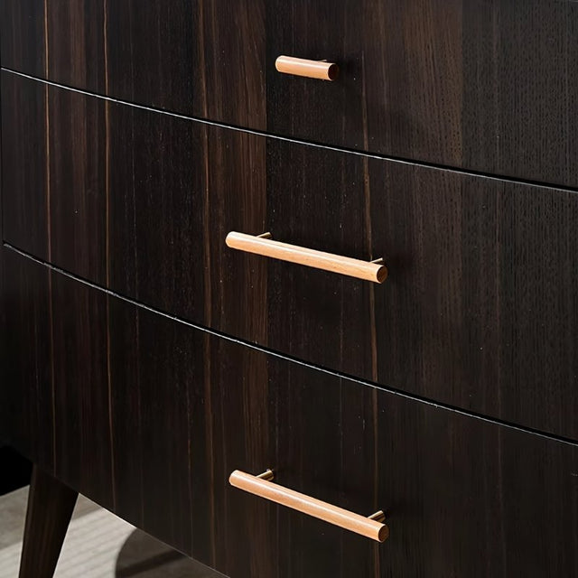 "Close-up of modern wooden drawer pulls with brass accents on a dark wood dresser."