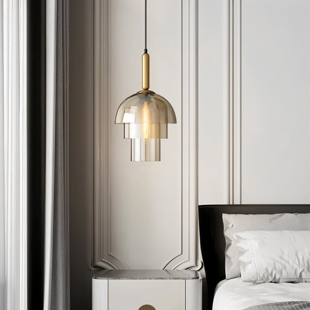 "Modern pendant light with layered smoked glass shade and metallic accent in a bedroom setting."