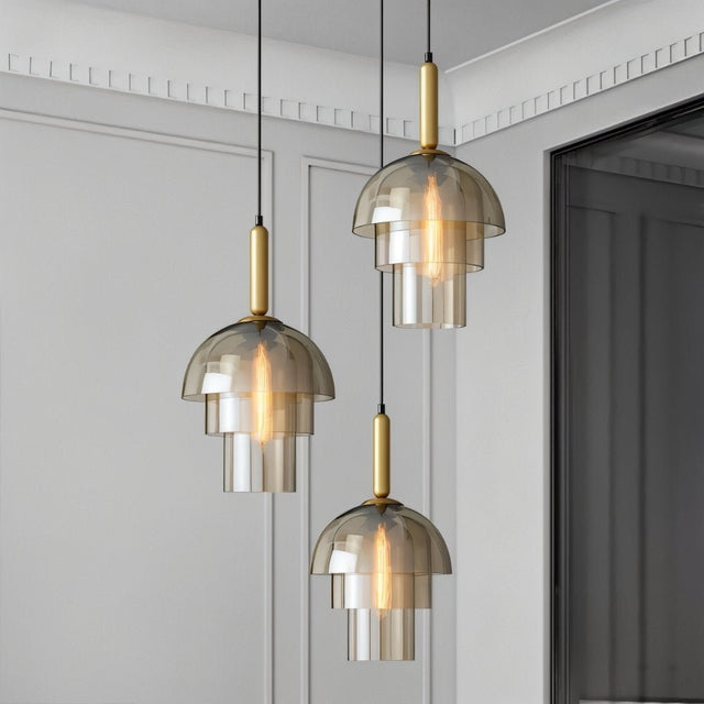 "Three modern pendant lights with layered smoked glass shades and metallic accents in a contemporary living room."