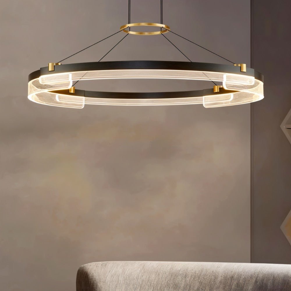 "Black and gold Capli chandelier with a single aluminum ring and acrylic diffusers, hanging above a sofa."