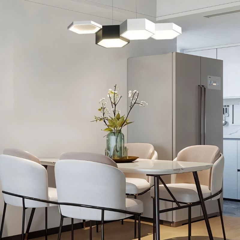 "A hexagonal pendant light with multiple heads, illuminating a modern dining table with white chairs."