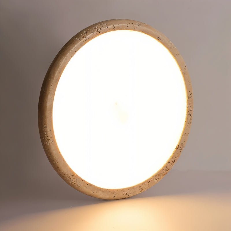 "A modern travertine flush mount ceiling light with a circular design, featuring a yellow travertine frame and a white acrylic diffuser, emitting a soft, warm glow."