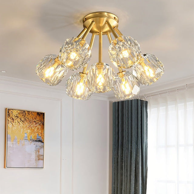 "Modern crystal ceiling light with brass finish in a bright dining room setting."