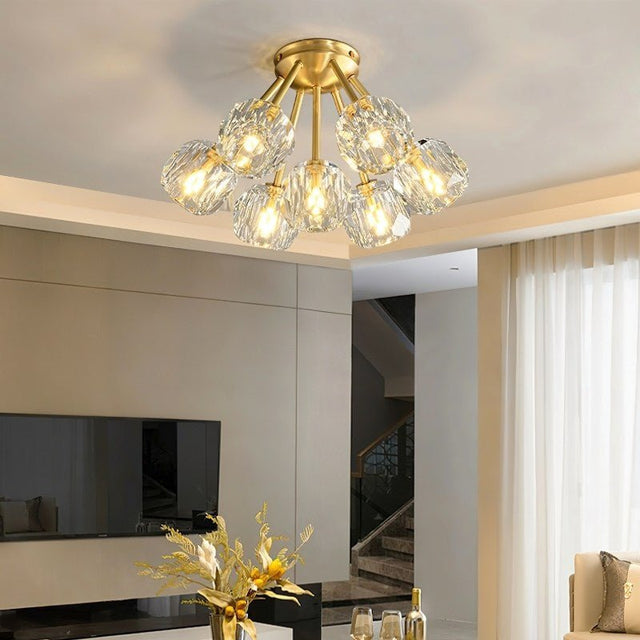 "Modern crystal ceiling light with brass finish in a contemporary living room setting."