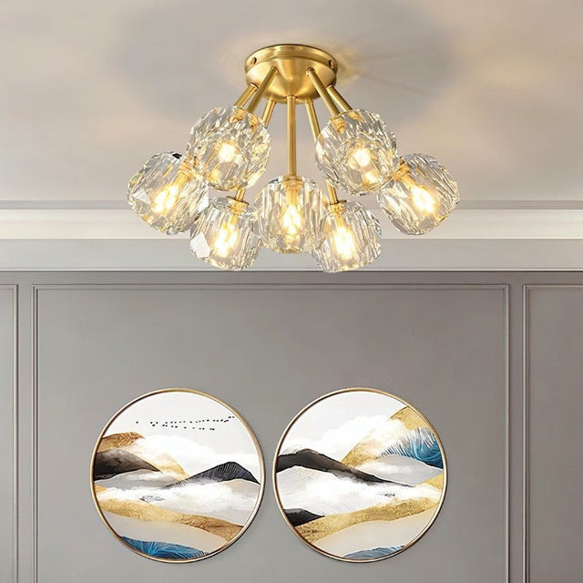 "Modern ceiling light with crystal shades and brass finish in a living room, illuminating artwork and decor."