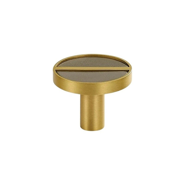 "Circular brass knob with a taupe leather inlay and central bar."