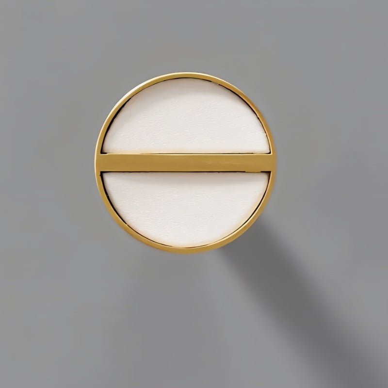 "Circular brass and white leather cabinet knob with a modern, luxurious design."