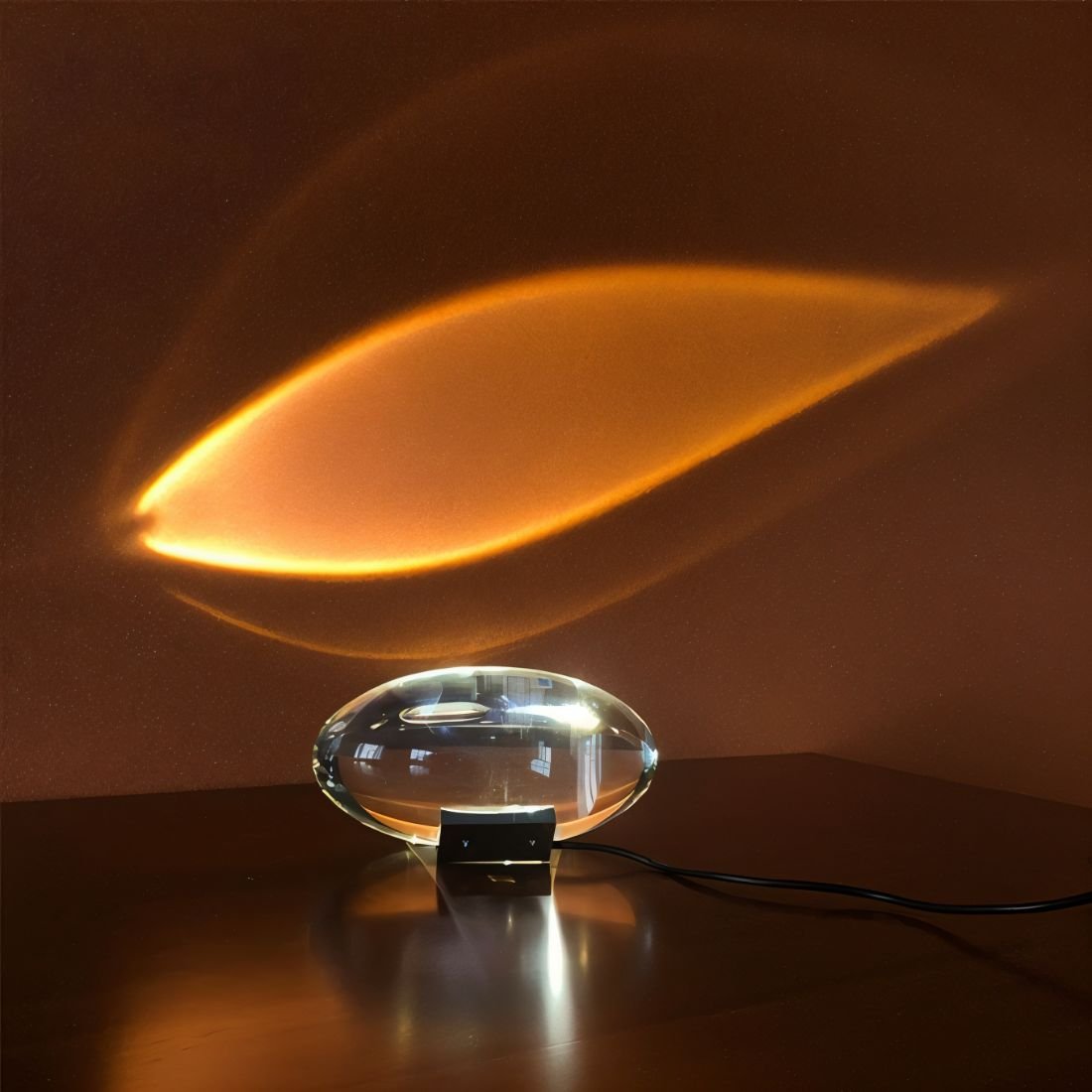 Crystal Eye table lamp with warm amber glow projecting onto dark background.