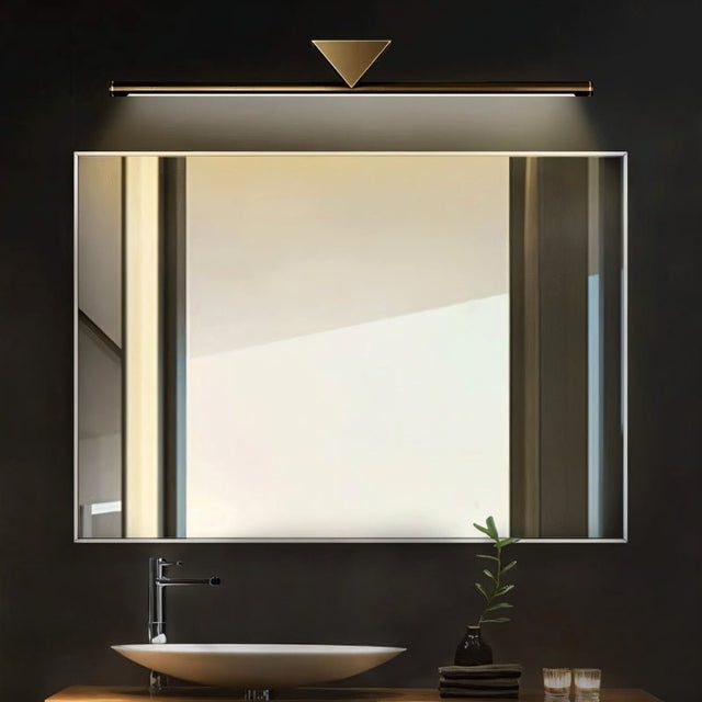 "A modern, linear LED wall lamp with a geometric accent illuminating a bathroom mirror with a sink."