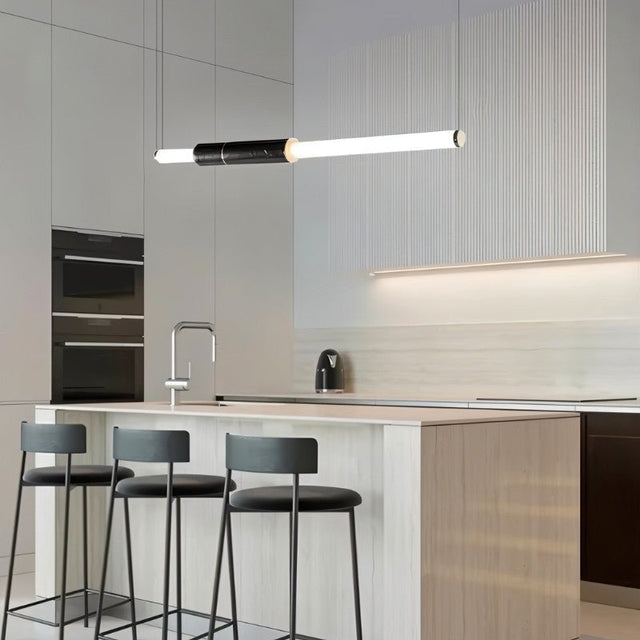 "Modern pendant light with a marble accent and acrylic tubes illuminating a contemporary kitchen island."