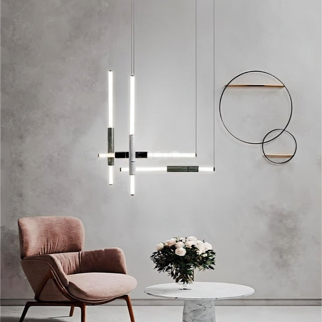 "Modern geometric pendant light with acrylic tubes and marble accents in a contemporary living room setting."