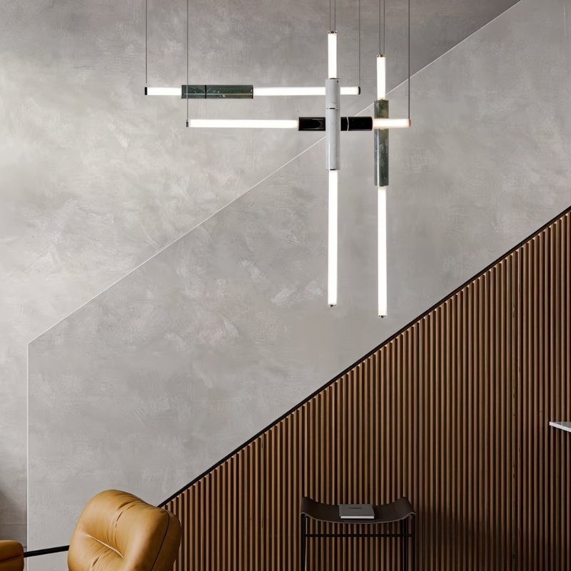 "Modern geometric pendant light with acrylic tubes and marble accents illuminating a contemporary staircase."