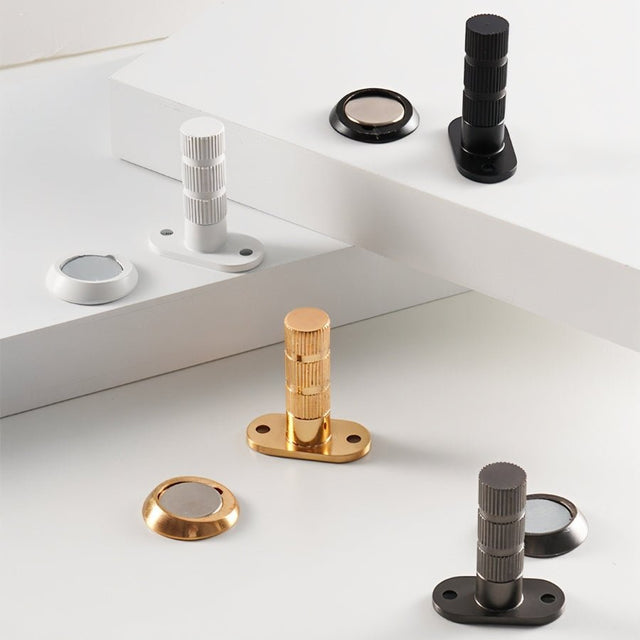 "Modern magnetic door stops in various finishes, including white, black, gold, and brushed nickel."