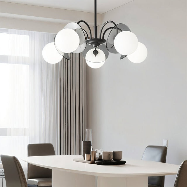 "Copper Dyana chandelier with frosted glass globes hanging above a white oval dining table with grey chairs."