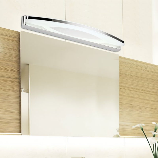 "A stainless steel LED vanity light mounted above a bathroom mirror with modern wood paneling."