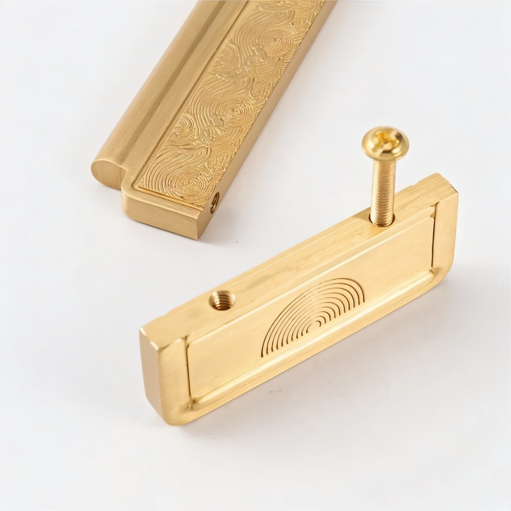 "Close-up of textured gold Erdas pull bar handles with visible screw."