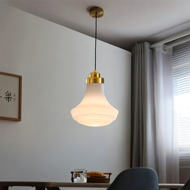 "Retro pendant light with a bell-shaped, striped glass shade and brass accents hanging above a dining table, creating a warm, inviting ambiance with a unique play of light and shadow."